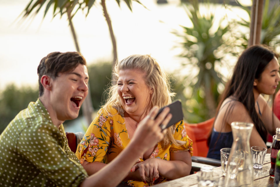 Two friends are laughing and taking a selfie