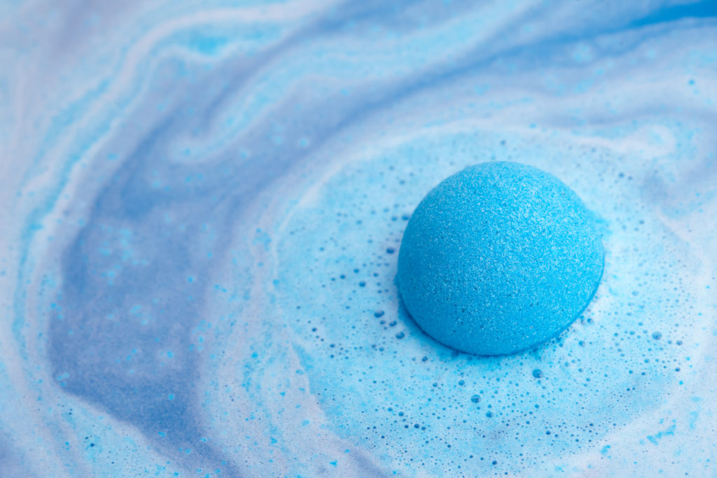 Blue bath bomb foaming in water