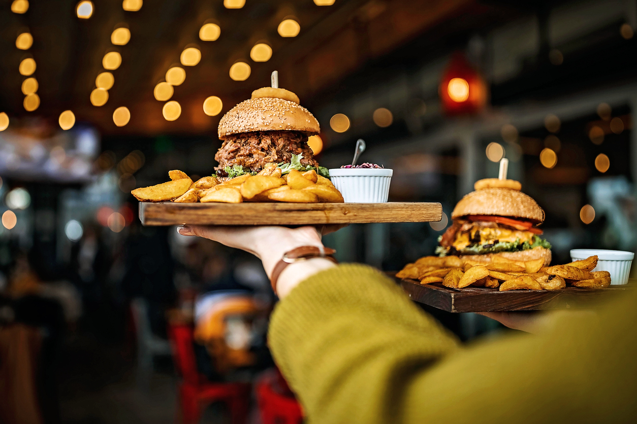 woman server carrying burgers