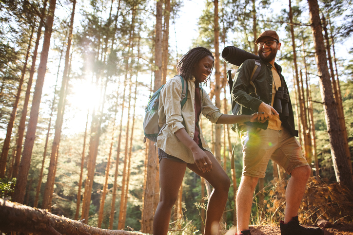 Love couple hikers in the forest, walking and speaking for a good place for camping