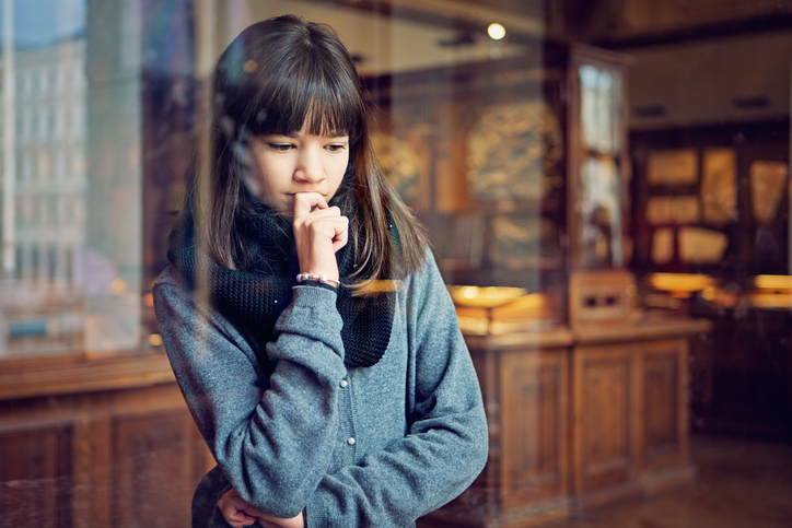 Serious teenage girl is looking museum exhibition with interest